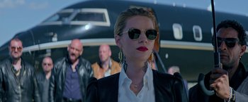 Movie still from “The Machine” (2023), directed by Peter Atencio – A woman wearing sunglasses and a leather jacket; Close Up shot, Low angle