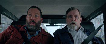 Movie still from “The Machine” (2023), directed by Peter Atencio – Two men sitting in the back seat of a car; Close Up shot, Low angle