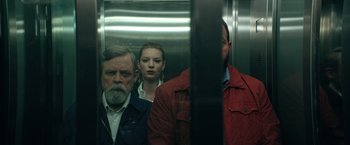 Movie still from “The Machine” (2023), directed by Peter Atencio – A man and a woman in an elevator with another man; Medium shot, Low angle