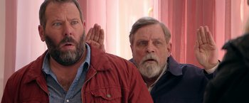 Movie still from “The Machine” (2023), directed by Peter Atencio – Two men standing next to each other in front of a window; Close Up shot, Over the shoulder angle