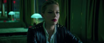 Movie still from “The Machine” (2023), directed by Peter Atencio – A woman with red lipstick wearing a leather jacket; Close Up shot, Over the shoulder angle