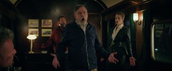 Movie still from “The Machine” (2023), directed by Peter Atencio – An older man with a surprised look on his face; Medium shot, Low angle