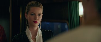 Movie still from “The Machine” (2023), directed by Peter Atencio – A beautiful woman with red lipstick wearing a black jacket; Close Up shot, Over the shoulder angle