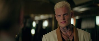 Movie still from “The Machine” (2023), directed by Peter Atencio – A man with white hair and a tattoo on his neck; Close Up shot, Over the shoulder angle