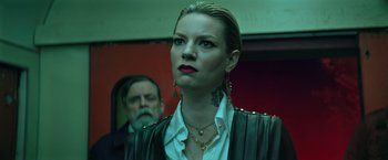 Movie still from “The Machine” (2023), directed by Peter Atencio – A woman wearing a white shirt and a leather jacket; Close Up shot, Low angle