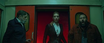 Movie still from “The Machine” (2023), directed by Peter Atencio – A woman standing in front of a red door; Medium shot, Low angle
