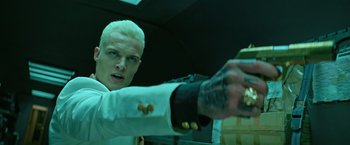 Movie still from “The Machine” (2023), directed by Peter Atencio – A man in a white shirt is holding food; Close Up shot, Low angle