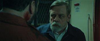 Movie still from “The Machine” (2023), directed by Peter Atencio – An older man with a beard is talking to a younger man; Close Up shot, Over the shoulder angle