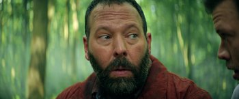 Movie still from “The Machine” (2023), directed by Peter Atencio – A person with a beard; Close Up shot, Low angle