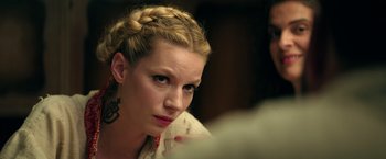 Movie still from “The Machine” (2023), directed by Peter Atencio – A person with a braid; Close Up shot, Over the shoulder angle