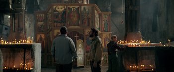 Movie still from “The Machine” (2023), directed by Peter Atencio – A group of people standing in front of an altar; Wide shot, Low angle