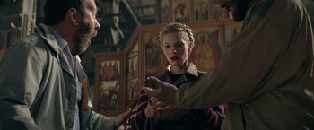 Movie still from “The Machine” (2023), directed by Peter Atencio – A woman is being interviewed by two men; Medium shot, Over the shoulder angle