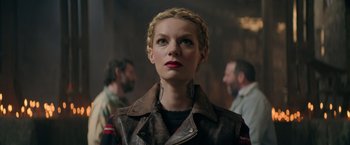 Movie still from “The Machine” (2023), directed by Peter Atencio – A woman in a leather jacket looking to her left; Close Up shot, Low angle