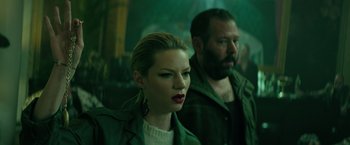 Movie still from “The Machine” (2023), directed by Peter Atencio – A man and a woman are standing next to each other; Close Up shot, Low angle