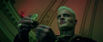 Movie still from “The Machine” (2023), directed by Peter Atencio – A person with tattoos on their face; Close Up shot, Low angle