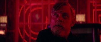 Movie still from “The Machine” (2023), directed by Peter Atencio – A person sitting in a room near a window; Close Up shot, Low angle