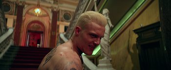 Movie still from “The Machine” (2023), directed by Peter Atencio – A person with tattoos on their face; Close Up shot, Low angle