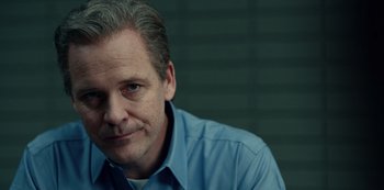 Movie still from “Dopesick” (2021), directed by Danny Strong – A person wearing a blue shirt; Close Up shot, Low angle