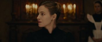 Movie still from “The Mad Women's Ball” (2021), directed by Mélanie Laurent – A person wearing a black shirt; Close Up shot, Low angle