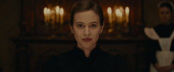 Movie still from “The Mad Women's Ball” (2021), directed by Mélanie Laurent – A person wearing a black shirt; Close Up shot, Low angle