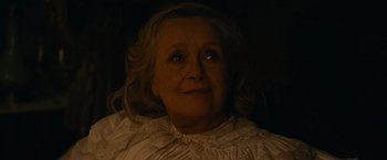 Movie still from “The Mad Women's Ball” (2021), directed by Mélanie Laurent – An older woman with blonde curly hair wearing a white dress; Close Up shot, High angle