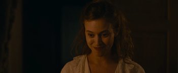 Movie still from “The Mad Women's Ball” (2021), directed by Mélanie Laurent – A young woman smiles brightly as she looks into the camera; Close Up shot, Over the shoulder angle