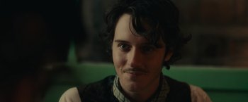 Movie still from “The Mad Women's Ball” (2021), directed by Mélanie Laurent – A person wearing a jacket; Close Up shot, Over the shoulder angle