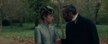 Movie still from “The Mad Women's Ball” (2021), directed by Mélanie Laurent – A man and a woman standing next to each other in a forest; Close Up shot, Over the shoulder angle
