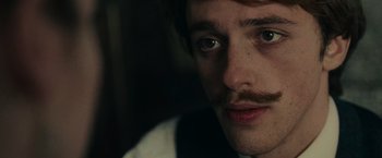 Movie still from “The Mad Women's Ball” (2021), directed by Mélanie Laurent – A person with a mustache; Close Up shot, Over the shoulder angle