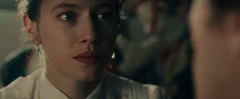 Movie still from “The Mad Women's Ball” (2021), directed by Mélanie Laurent – A woman's face in a dark room; Close Up shot, Over the shoulder angle