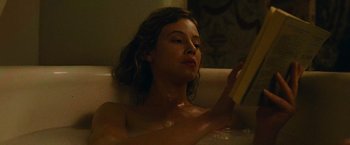 Movie still from “The Mad Women's Ball” (2021), directed by Mélanie Laurent – A woman sitting in a bath tub reading a book; Close Up shot, High angle