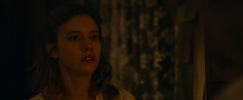 Movie still from “The Mad Women's Ball” (2021), directed by Mélanie Laurent – A young woman with long brown hair is looking at the camera; Close Up shot, Over the shoulder angle