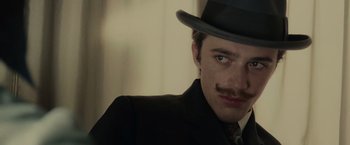 Movie still from “The Mad Women's Ball” (2021), directed by Mélanie Laurent – A man in a suit and a top hat; Close Up shot, Low angle