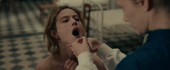 Movie still from “The Mad Women's Ball” (2021), directed by Mélanie Laurent – A woman is being examined by a doctor; Close Up shot, Over the shoulder angle