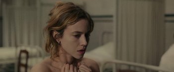 Movie still from “The Mad Women's Ball” (2021), directed by Mélanie Laurent – A beautiful young woman with a piercing in her ear; Close Up shot, Over the shoulder angle