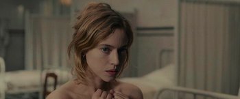Movie still from “The Mad Women's Ball” (2021), directed by Mélanie Laurent – A beautiful young woman with a bare chest; Close Up shot, High angle