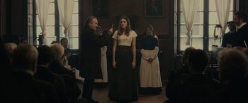 Movie still from “The Mad Women's Ball” (2021), directed by Mélanie Laurent – A group of people standing in a room; Medium shot, Low angle