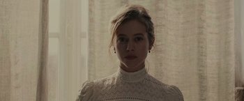 Movie still from “The Mad Women's Ball” (2021), directed by Mélanie Laurent – A woman in a white dress standing in front of a window; Close Up shot, Low angle