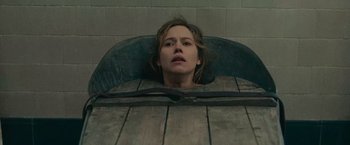 Movie still from “The Mad Women's Ball” (2021), directed by Mélanie Laurent – A woman laying in a chair with her eyes closed; Medium shot, High angle