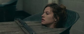 Movie still from “The Mad Women's Ball” (2021), directed by Mélanie Laurent – A person laying on a bench; Close Up shot, High angle