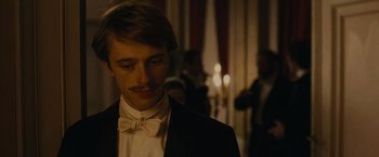 Movie still from “The Mad Women's Ball” (2021), directed by Mélanie Laurent – A man in a tuxedo with a bow tie; Close Up shot, Low angle