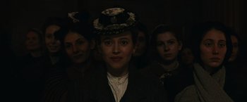Movie still from “The Mad Women's Ball” (2021), directed by Mélanie Laurent – A group of women standing next to each other in a dark room; Close Up shot, Low angle