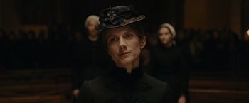 Movie still from “The Mad Women's Ball” (2021), directed by Mélanie Laurent – A woman wearing a hat with a flower on it; Close Up shot, Low angle