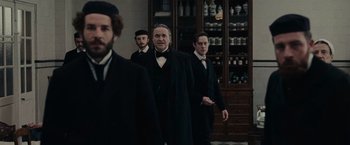Movie still from “The Mad Women's Ball” (2021), directed by Mélanie Laurent – A group of men standing next to each other in a room; Medium shot, Low angle