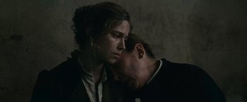 Movie still from “The Mad Women's Ball” (2021), directed by Mélanie Laurent – A man and a woman are kissing in a dark room; Close Up shot, Over the shoulder angle