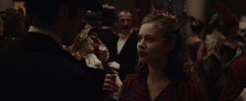 Movie still from “The Mad Women's Ball” (2021), directed by Mélanie Laurent – A woman in a striped shirt is looking at a man in a black suit; Close Up shot, Over the shoulder angle