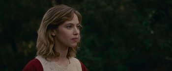 Movie still from “The Mad Women's Ball” (2021), directed by Mélanie Laurent – A young woman is standing in front of a forest; Close Up shot, Low angle