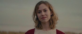 Movie still from “The Mad Women's Ball” (2021), directed by Mélanie Laurent – A young woman with long blonde hair wearing a red sweater; Close Up shot, Low angle