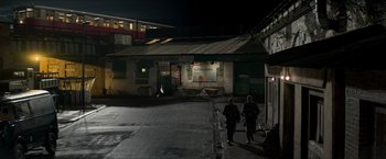 Movie still from “The Man from U.N.C.L.E.” (2015), directed by Guy Ritchie – Two people are walking down the street at night; Extreme Wide shot, High angle