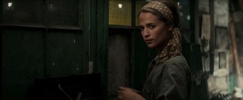 Movie still from “The Man from U.N.C.L.E.” (2015), directed by Guy Ritchie – A woman with a head scarf standing next to a door; Close Up shot, Over the shoulder angle